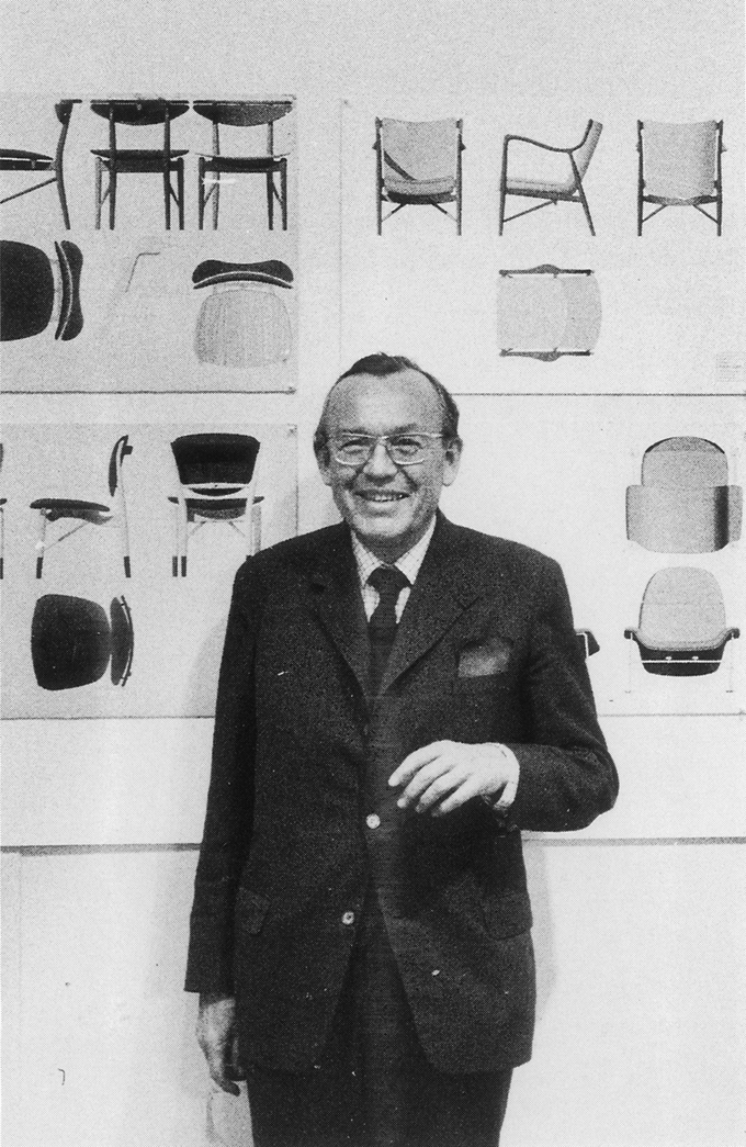 チェアのデザイン画の前に立つフィン・ユールの写真