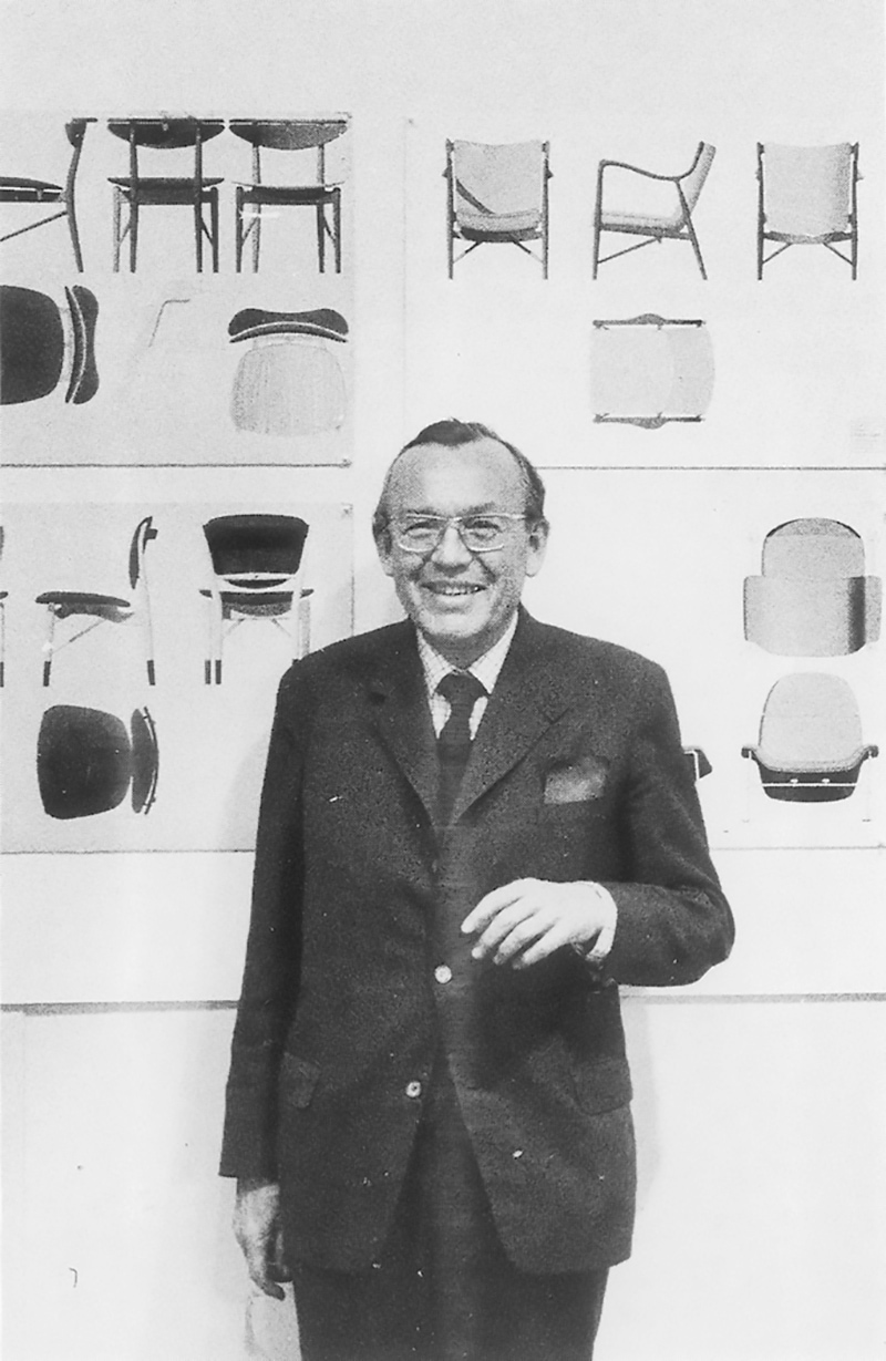 チェアのデザイン画の前に立つフィン・ユールの写真