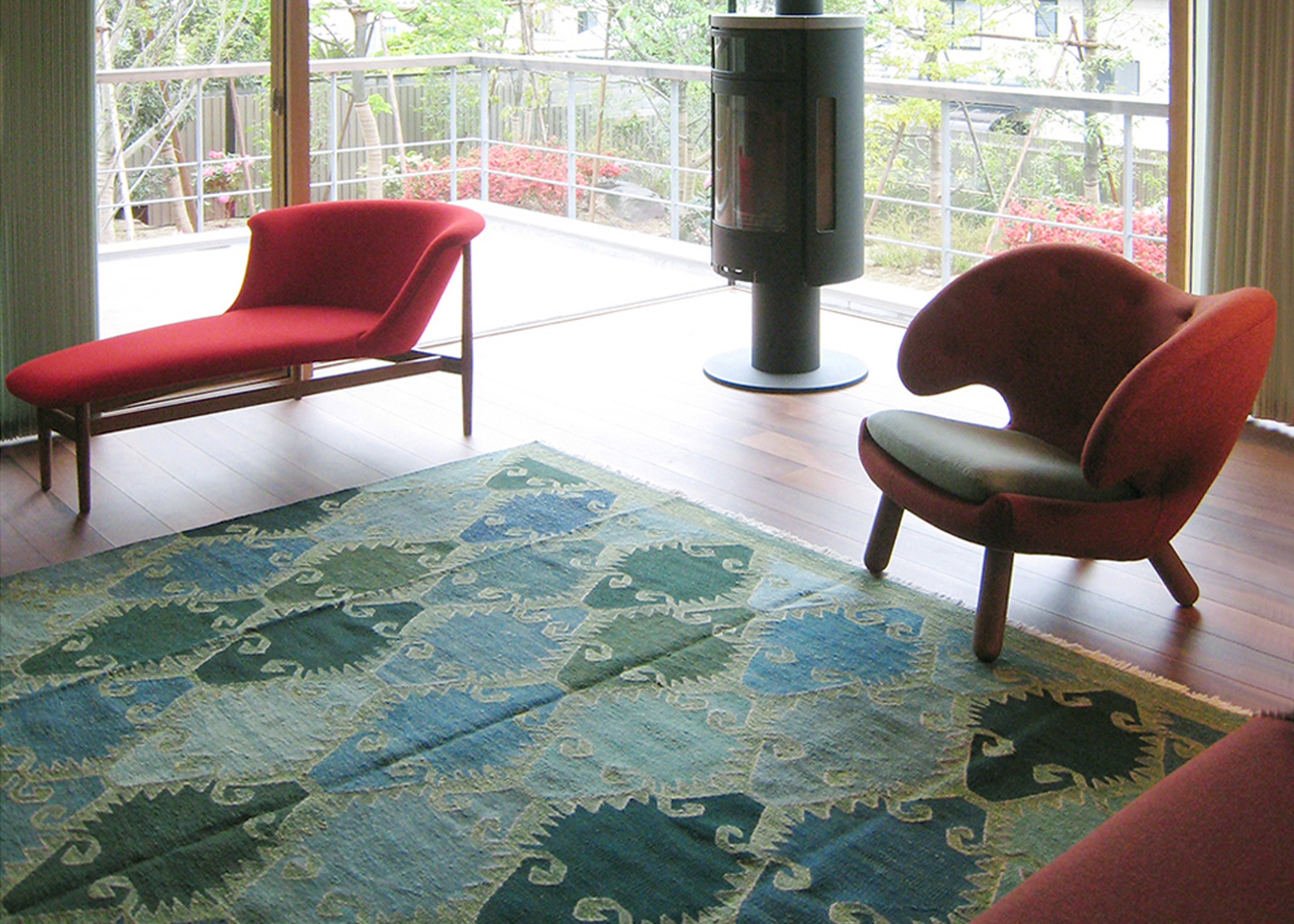 ラウンジチェアの側に敷かれたグリーンのロゴバキリムの写真